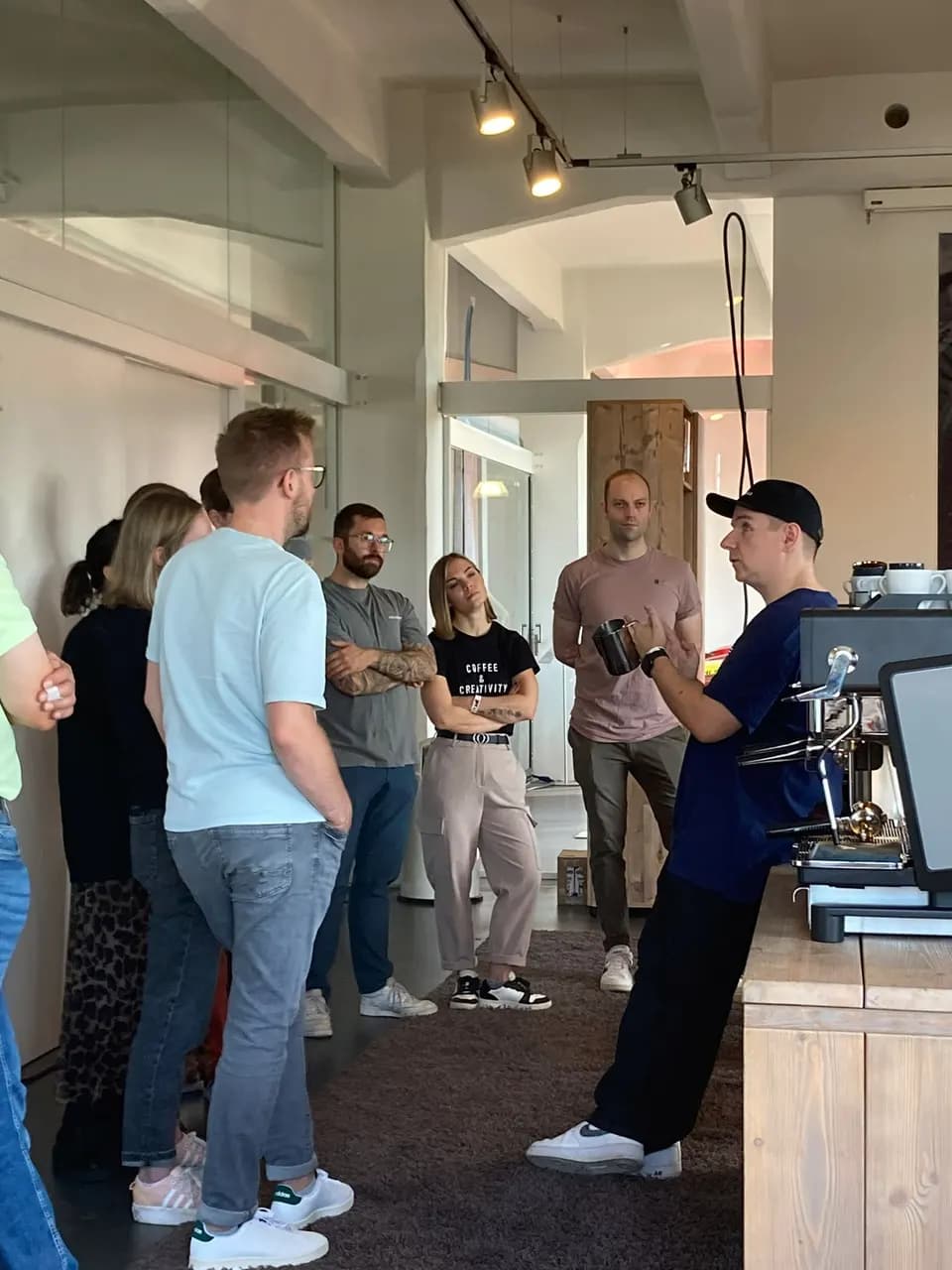 Kai Mößner erklärt einer Gruppe im Trainingsraum die Arbeit an der Espressomaschine