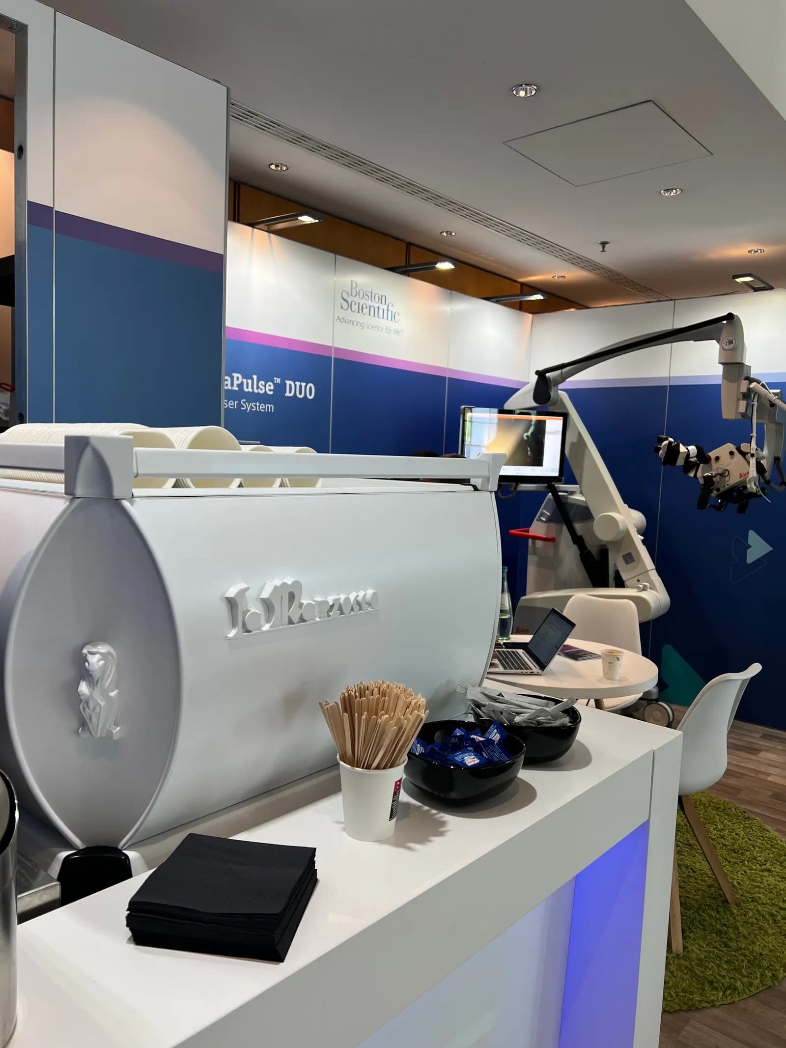 Weißes Barmodul mit beleuchteter Front, darauf eine La-Marzocco-Siebträgermaschine, an einem Messestand
