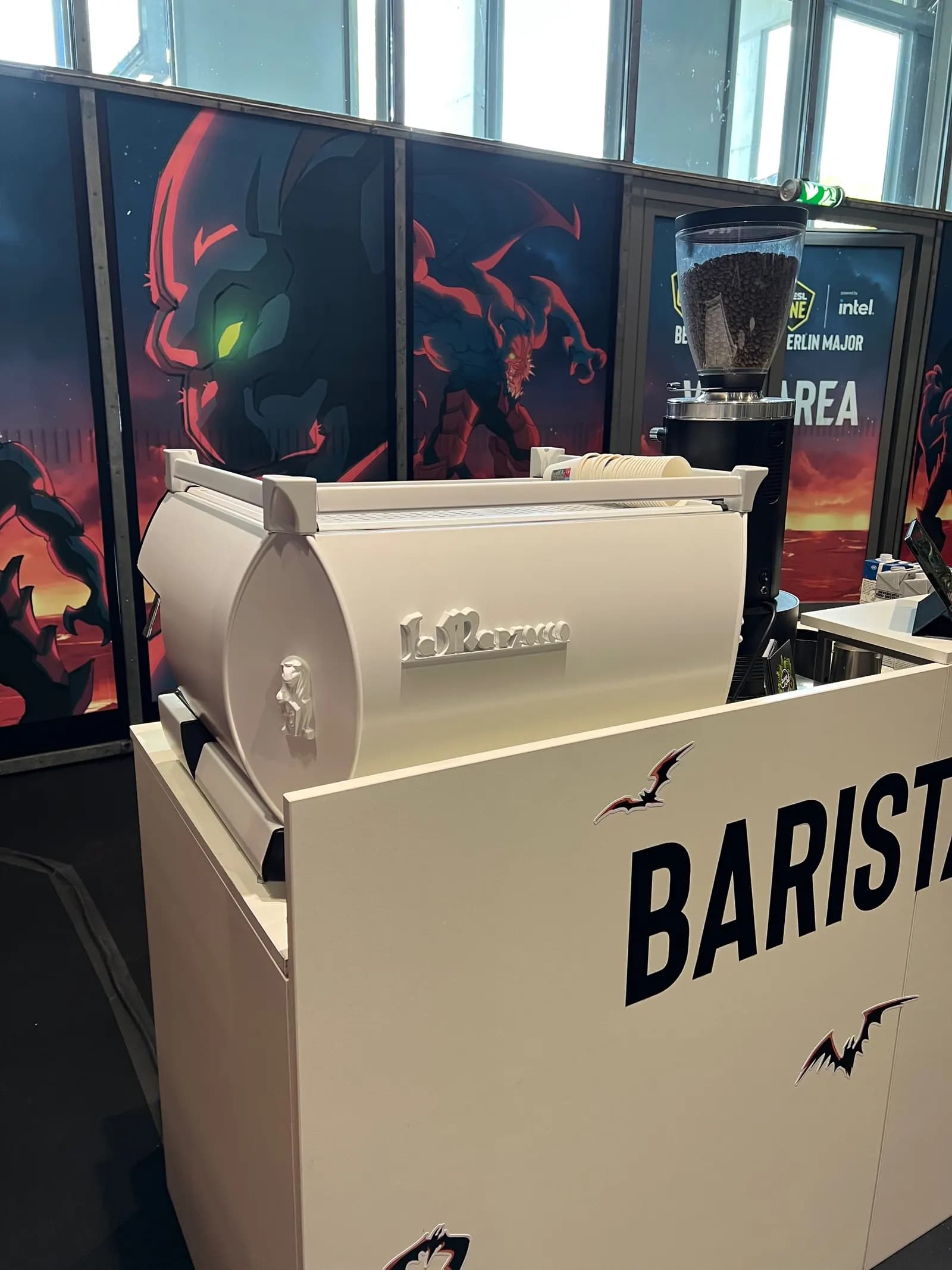 Weißes Barmodul mit gebrandeter Front, darauf eine La-Marzocco-Siebträgermaschine